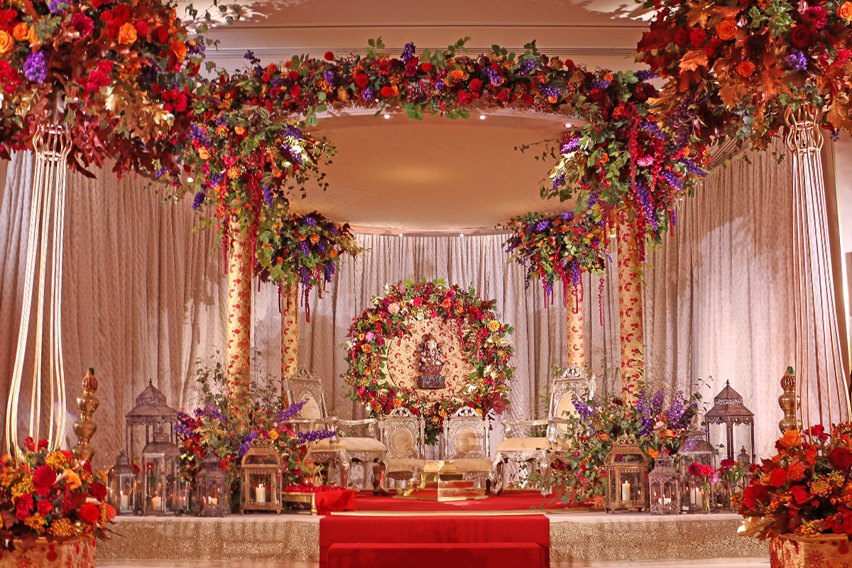 Autumnal Mandap at The Grove. Fabric covered pillars with Halo of flowers in the backdrop